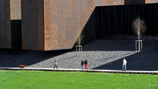 Personnes sur la promenade piétonne devant les blocs d'acier Corten du musée Soulages de Rodez