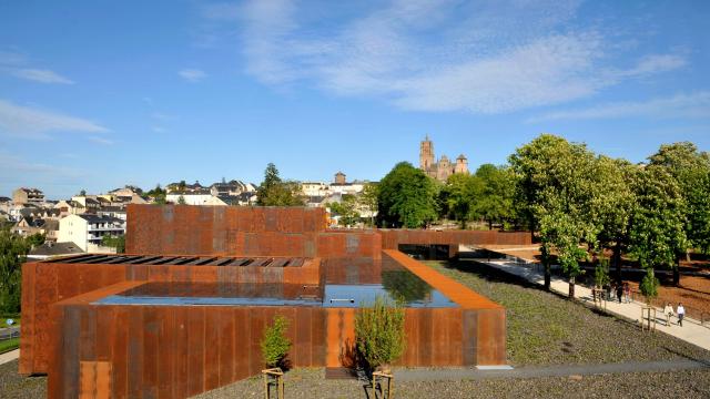 Vue aérienne du toit du musée Soulages de Rodez avec son acier Corten, et la cathédrale au loin