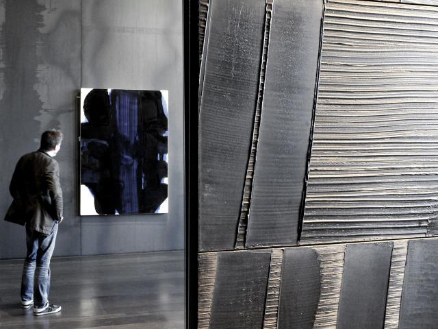Outrenoir au premier plan, derrière une personne qui admire une autre toile avec des bleus, au musée Soulages à Rodez