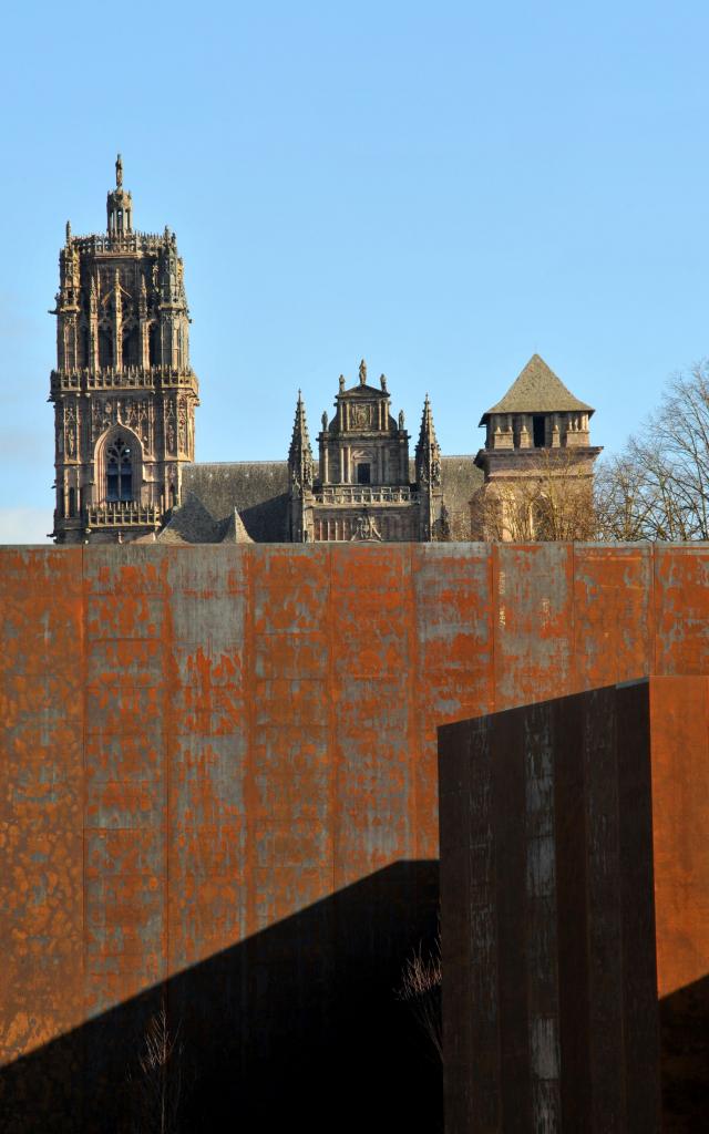 Le mur en acier Corten du musée Soulages contraste avec la cathédrale en arrière-plan