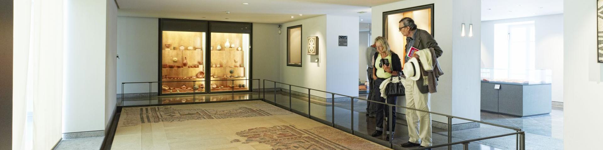 Couple de touristes admirant la mosaïque gallo-romaine exposée au sol au musée Fenaille à Rodez