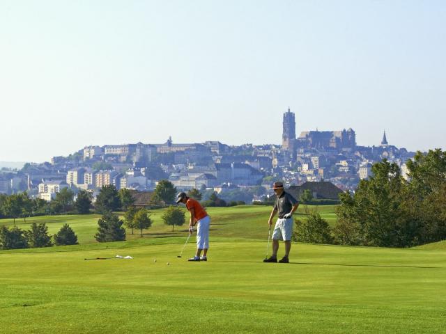 Deux hommes jouent au golf sur le green, avec la cathédrale en arrière-plan