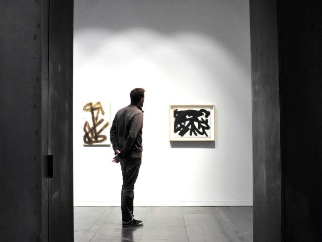Personne admirant deux tableaux Brous de noix au musée Soulages