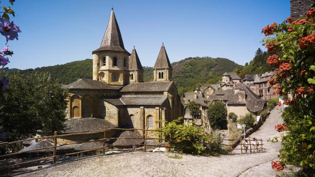 Au bord d'un chemin pavé, abbaye Cistercienne au cœur du village typique de Conques