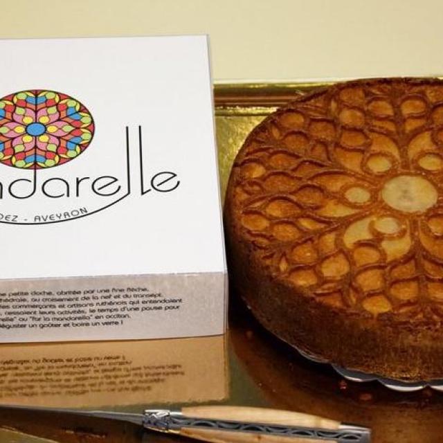 Gâteau La Mandarelle à côté de sa boîte en carton au logo éponyme