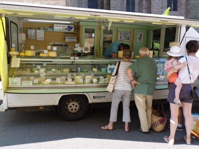 Personnes achetant du fromage à un marchand dans un camion ambulant au marché de Rodez