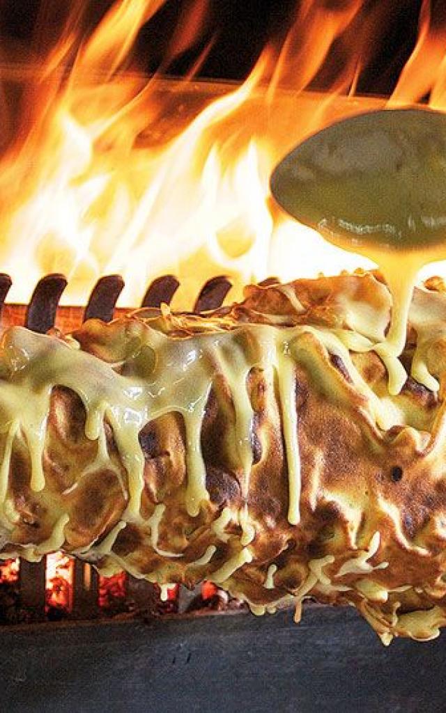 Cuisson d'un gâteau à la broche, spécialité aveyronnaise conique, au feu de bois. La pâte coule pour former les picots