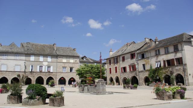 Place du village avec des arcades et une croix, de la Bastide de Sauveterre De Rouergue
