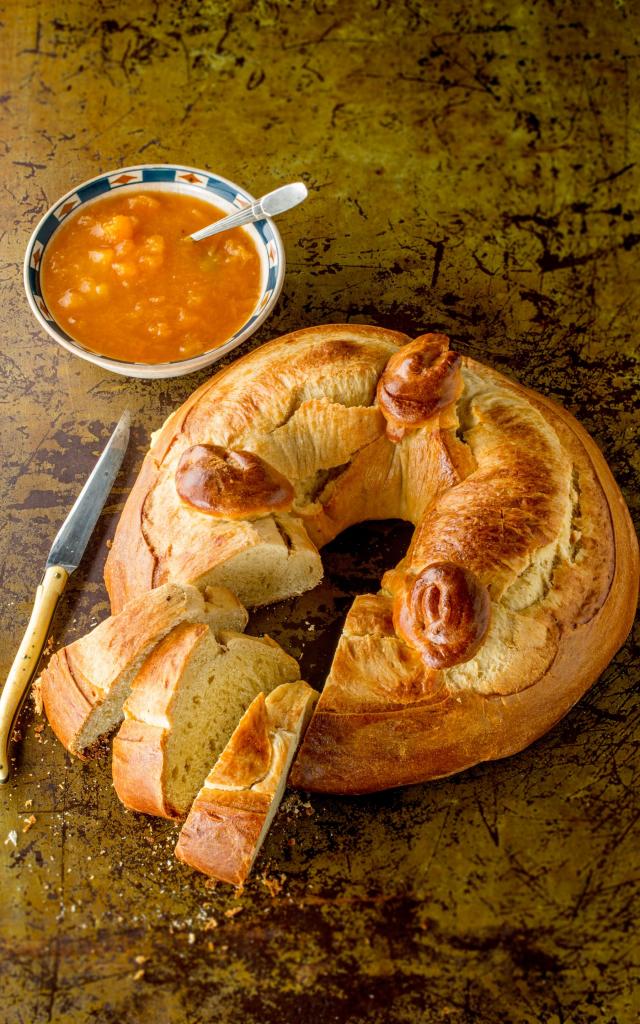 Gâteau de fouace avec trois parts tranchées, à côté d'un couteau Laguiole et d'un bol de confiture