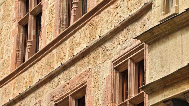 Façade avec des fenêtres à meneaux en grès rose d'une maison ruthénoise