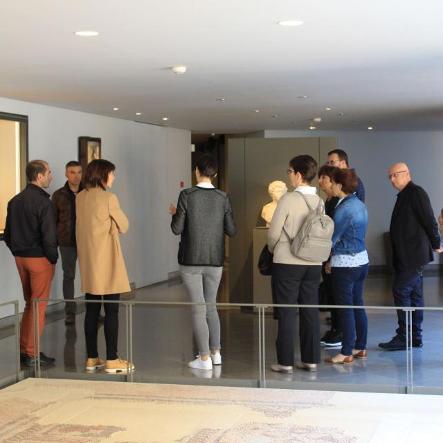 Groupe de visiteurs autour de la guide, au musée Fenaille
