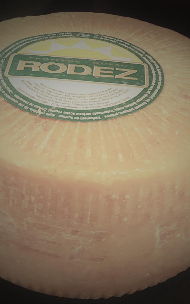 Meule ronde entière de fromage Le Rodez avec son étiquette au sommet blanche et verte