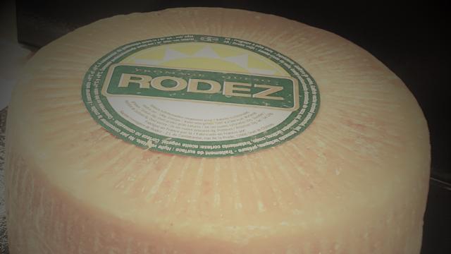 Meule ronde entière de fromage Le Rodez avec son étiquette au sommet blanche et verte
