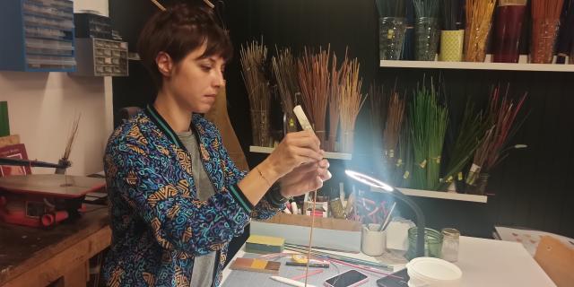 Personne s'affairant dans un atelier de marqueterie de paille