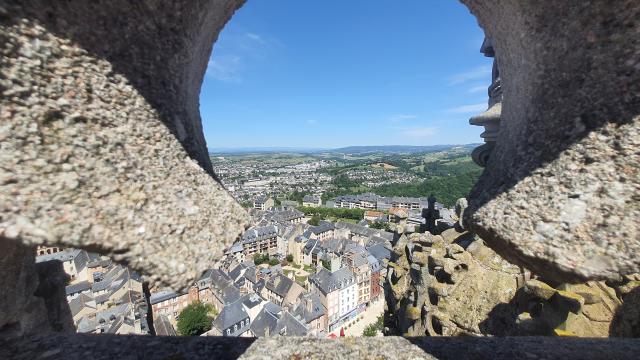 Vue sur le centre historique de Rodez à travers une fenêtre sculptée en pierre du clocher de la cathédrale